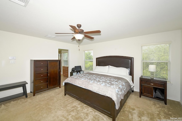 carpeted bedroom with multiple windows and ceiling fan