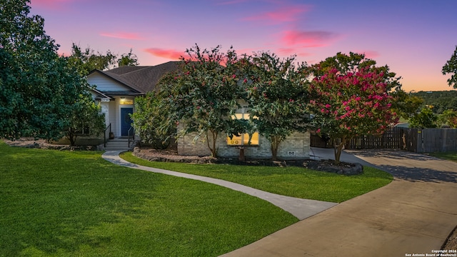 view of property hidden behind natural elements featuring a lawn