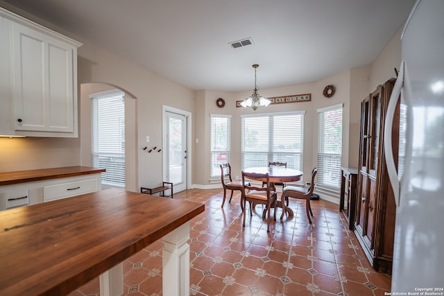 tiled dining room with a notable chandelier