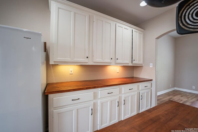 kitchen featuring white cabinetry, white refrigerator, dark hardwood / wood-style flooring, and wood counters