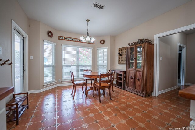 tiled dining area featuring a chandelier