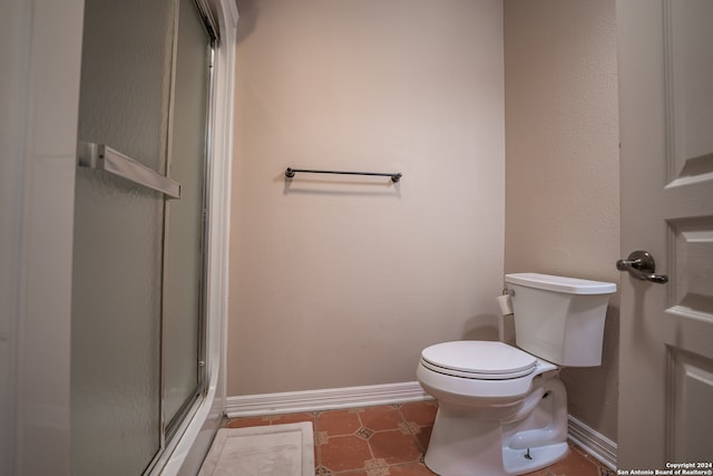 bathroom with walk in shower, toilet, and tile patterned floors