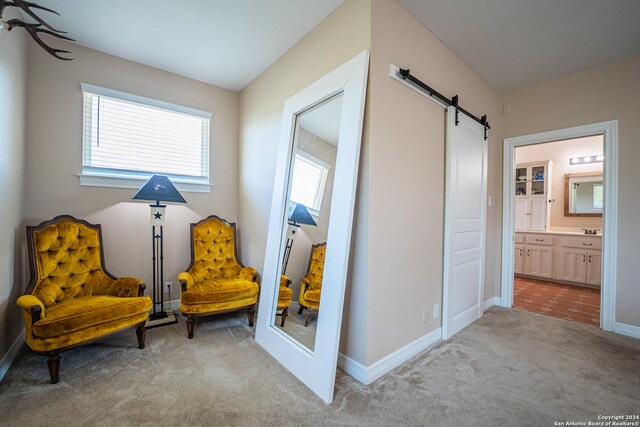 living area with light carpet and a barn door