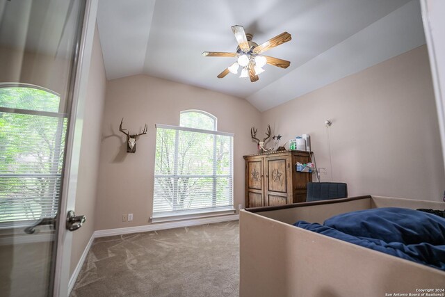 carpeted bedroom with ceiling fan and vaulted ceiling