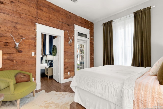 bedroom with wood walls and hardwood / wood-style floors