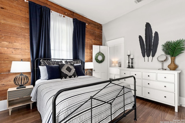 bedroom featuring wooden walls and dark wood-type flooring