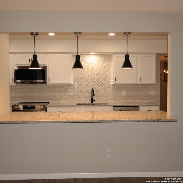 kitchen featuring dark wood-type flooring, backsplash, stainless steel appliances, and white cabinetry