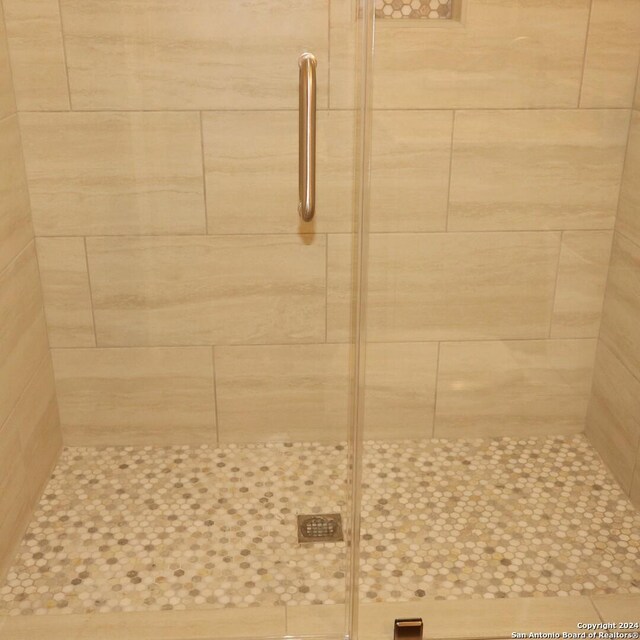 bathroom featuring a shower with door, vanity, and toilet