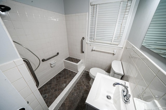 bathroom featuring vanity, tiled shower, tile walls, and toilet