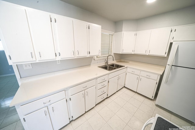 kitchen with white cabinetry, light tile patterned flooring, sink, and white fridge