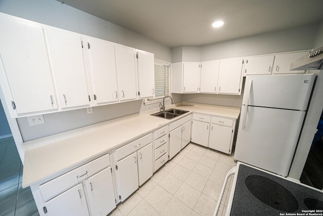 kitchen with white refrigerator, white cabinetry, sink, and light tile patterned flooring