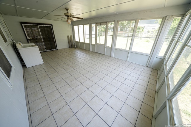 unfurnished sunroom with ceiling fan and separate washer and dryer