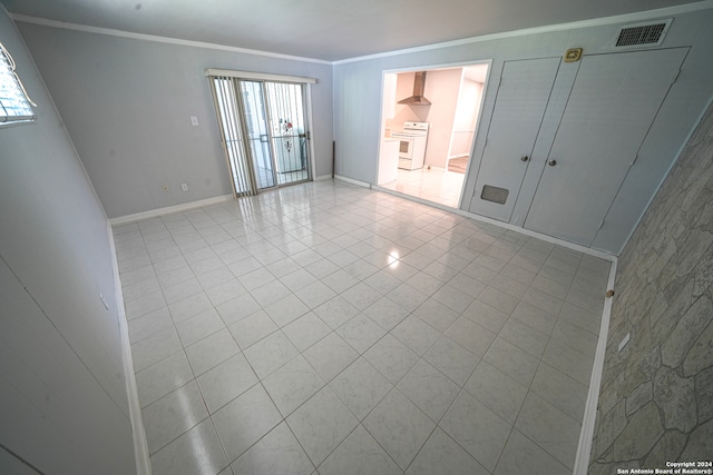 unfurnished bedroom with light tile patterned flooring, crown molding, and ensuite bathroom