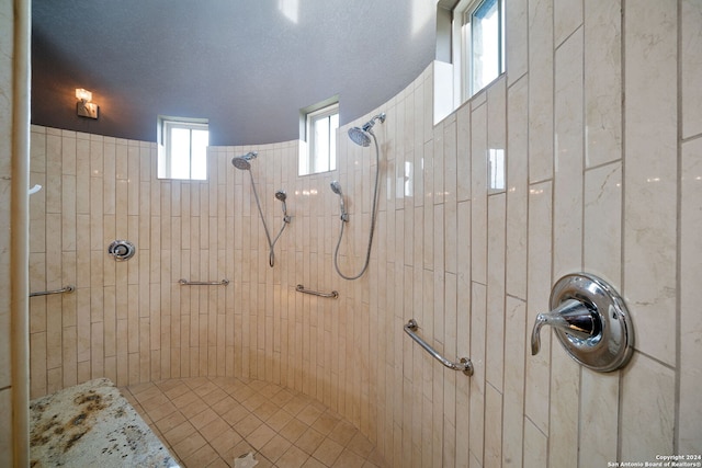 bathroom featuring a textured ceiling and a tile shower