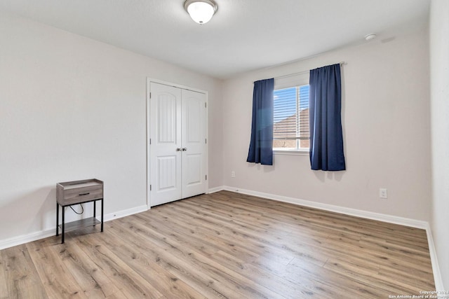 unfurnished bedroom featuring light wood-type flooring and a closet