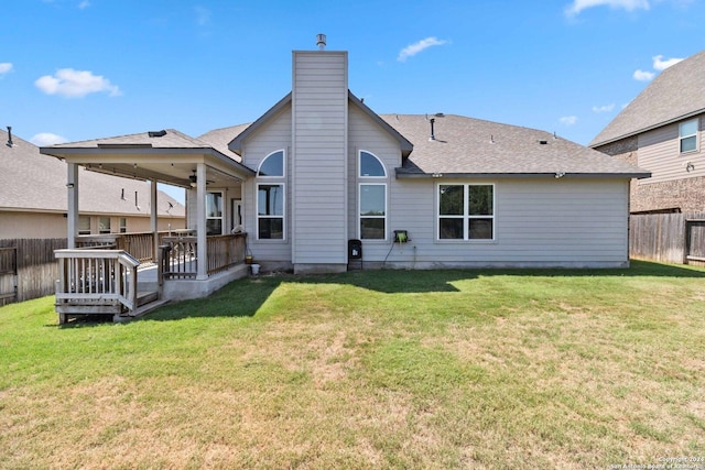 rear view of house with a wooden deck, ceiling fan, and a lawn