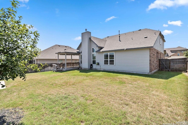 rear view of property featuring a lawn