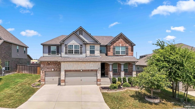 craftsman house with a garage, a front yard, and covered porch