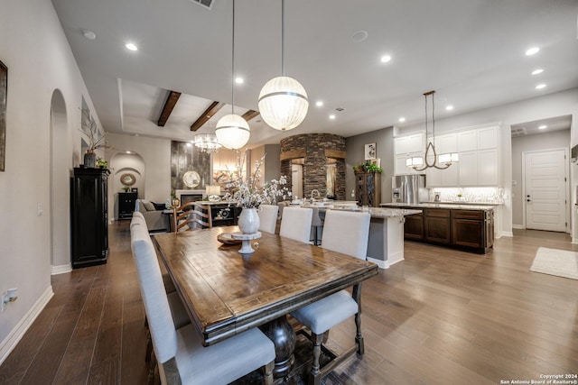 dining space with hardwood / wood-style flooring and beamed ceiling