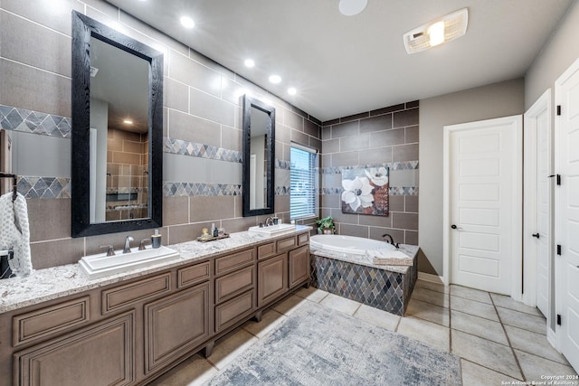 bathroom featuring vanity, tiled bath, tile patterned flooring, and tile walls