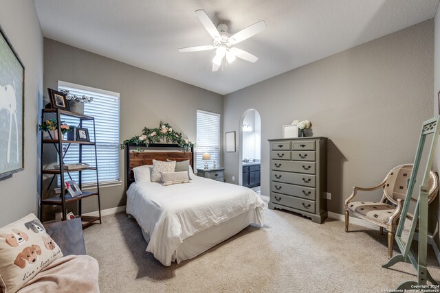 bedroom with ceiling fan, multiple windows, and light carpet