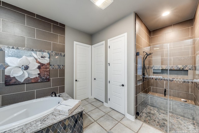 bathroom with separate shower and tub, tile patterned flooring, and tile walls