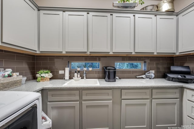 kitchen with gray cabinetry, sink, and backsplash