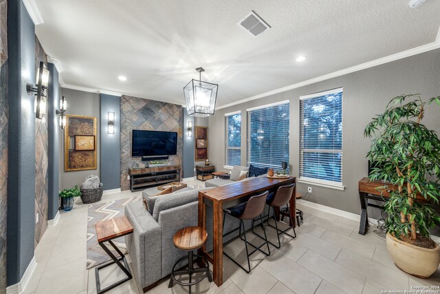 living room featuring light tile patterned floors, a textured ceiling, and crown molding