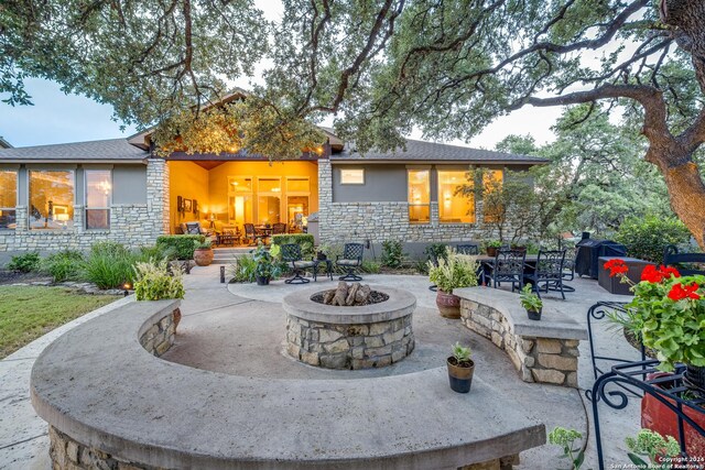 rear view of house featuring an outdoor fire pit and a patio