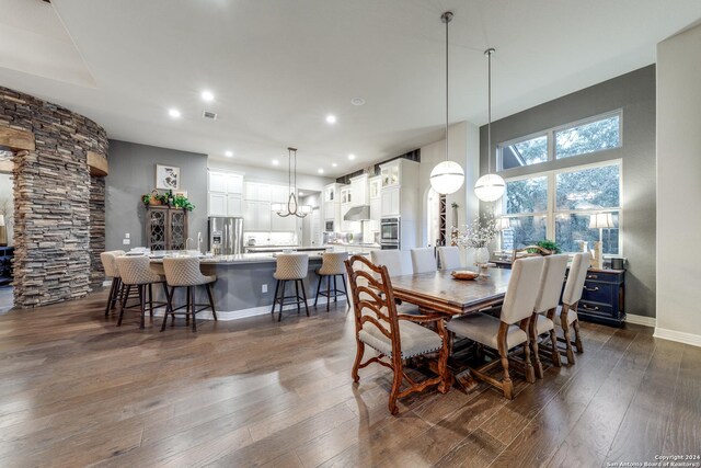 dining space with dark hardwood / wood-style flooring and an inviting chandelier