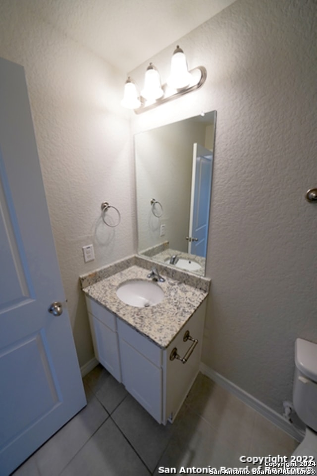 bathroom with vanity, tile patterned flooring, and toilet