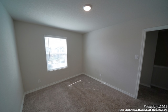 empty room featuring dark colored carpet