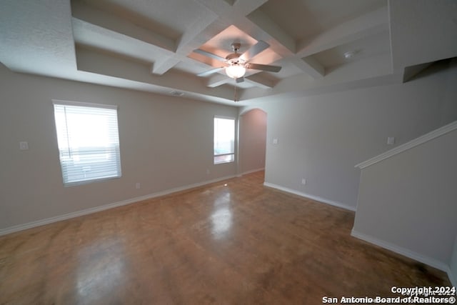 empty room featuring plenty of natural light, coffered ceiling, and ceiling fan