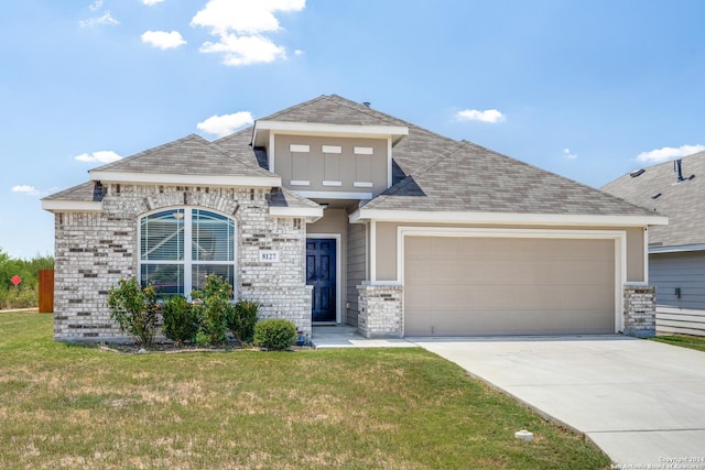 view of front of property with a garage and a front lawn