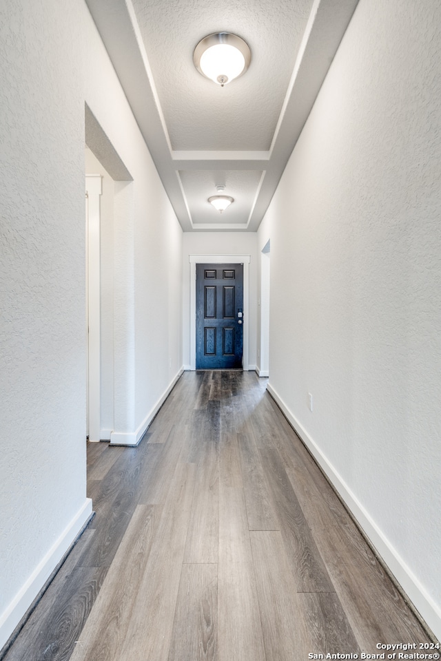 corridor featuring wood-type flooring and a textured ceiling