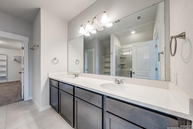 bathroom with double vanity, walk in shower, and tile patterned floors