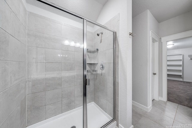 bathroom with walk in shower and tile patterned flooring