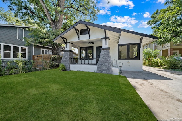 view of front of home with a front yard, ceiling fan, and covered porch