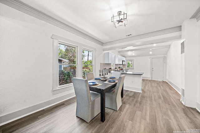 dining area with light hardwood / wood-style flooring, a chandelier, and ornamental molding