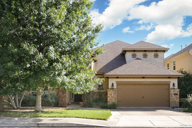 view of front of property featuring a garage, stone siding, driveway, roof with shingles, and stucco siding