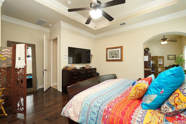 bedroom with ceiling fan, dark hardwood / wood-style flooring, a tray ceiling, and ornamental molding