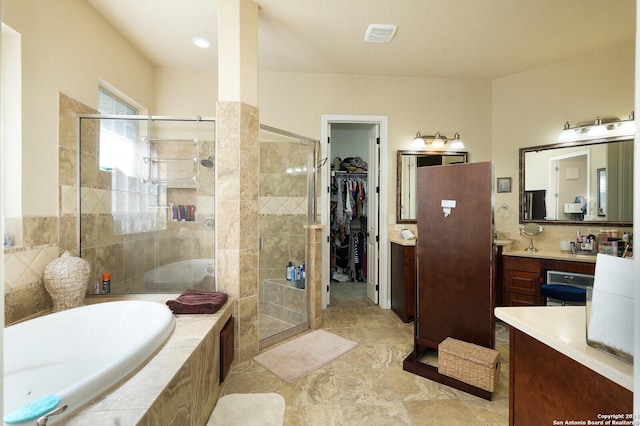 full bath featuring a garden tub, visible vents, vanity, a spacious closet, and a shower stall