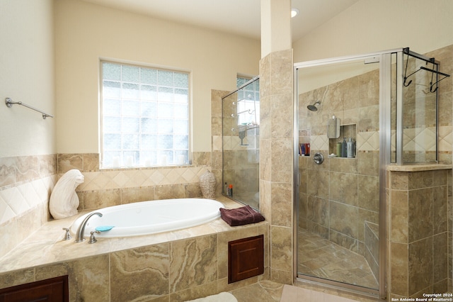 bathroom with tile patterned flooring, separate shower and tub, and lofted ceiling