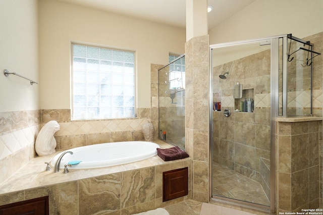 bathroom with vaulted ceiling, tiled shower, and a bath