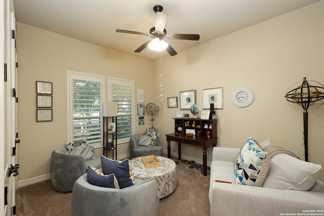 carpeted living room featuring baseboards and a ceiling fan