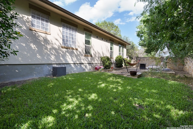 view of yard with central AC and a patio