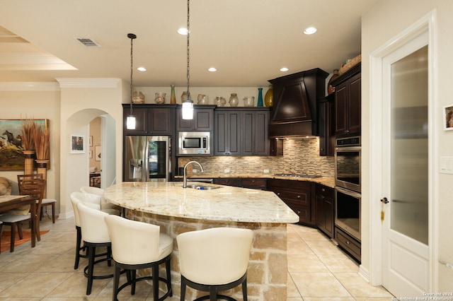 kitchen with decorative backsplash, custom range hood, appliances with stainless steel finishes, sink, and light tile patterned flooring