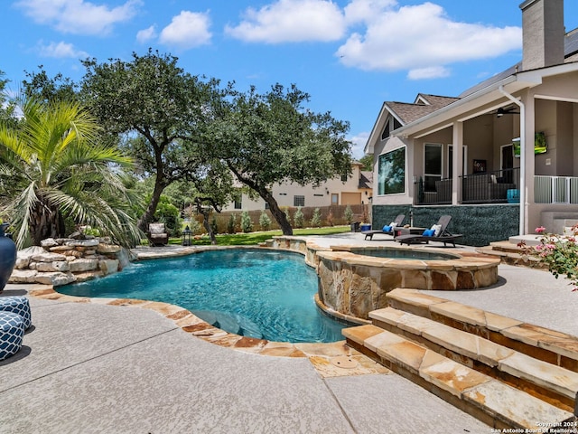 view of pool with ceiling fan, a patio, an in ground hot tub, and pool water feature