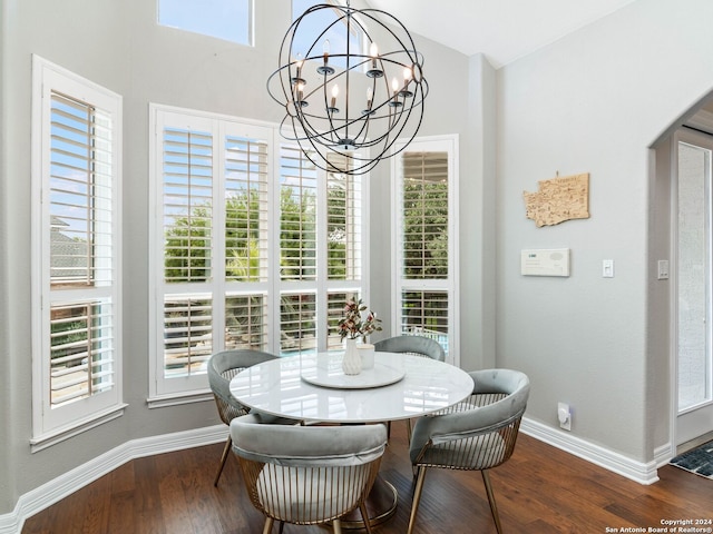 dining area with dark wood-type flooring and a chandelier