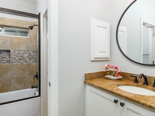 bathroom featuring tiled shower / bath combo and vanity